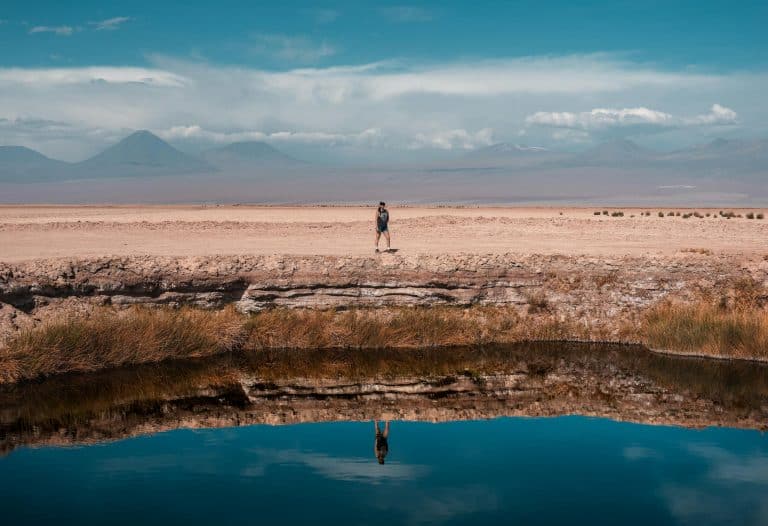 A serene scene in San Pedro de Atacama with desert reflection and mountains.