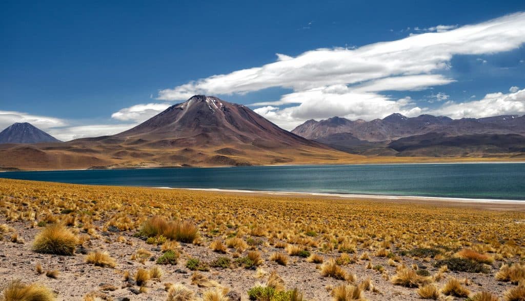Breathtaking view of a lake and mountains in the Atacama Desert, Chile under a clear blue sky.