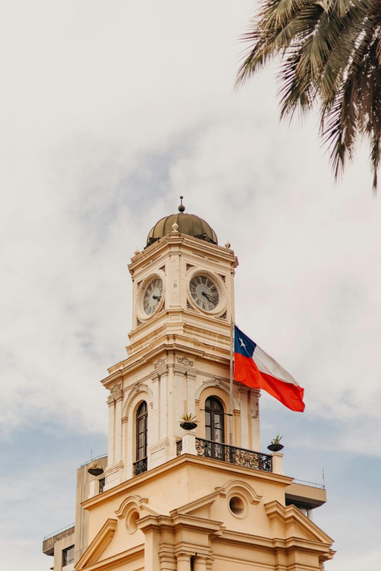 Iconic clock tower with Chilean flag in Santiago, capturing classic architecture and national pride.